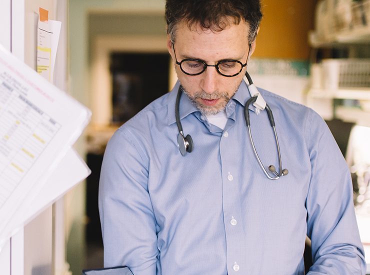 Dr. Hal Siden studies a book, pediatric palliative research at Canuck Place