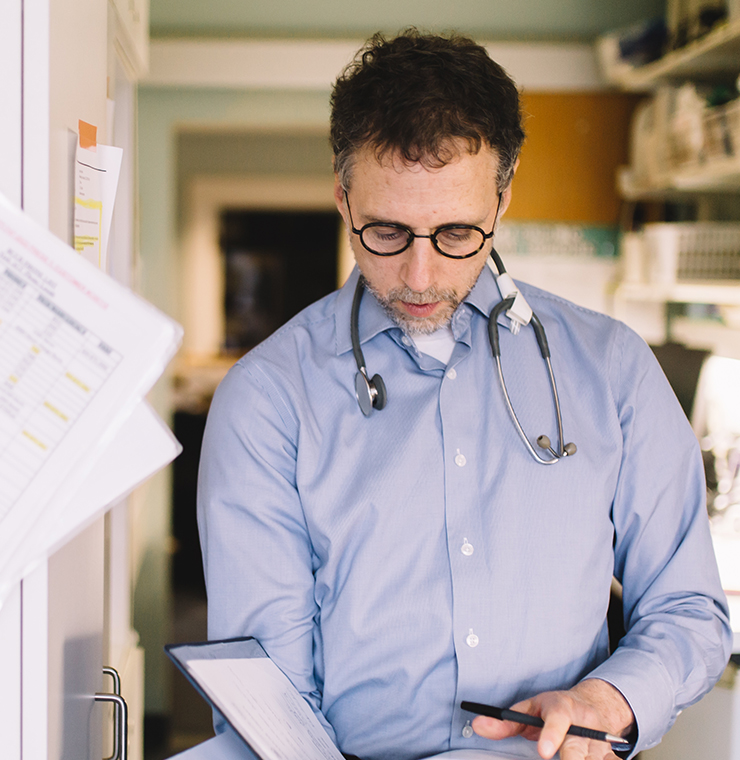 Dr. Hal Siden studies a book, pediatric palliative research at Canuck Place